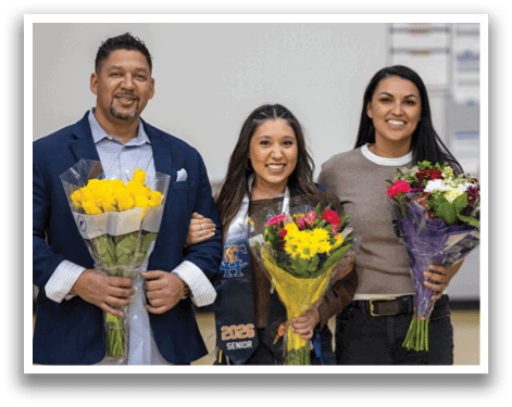 A young man and woman stand together in front of a banner. The woman is holding a bouquet of flowers. AI generated content
