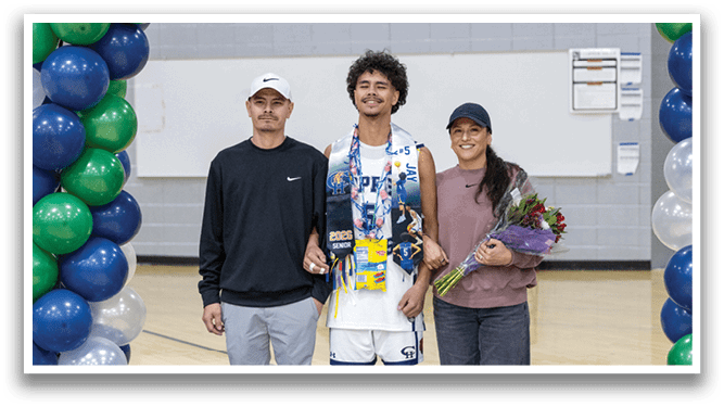 A man and woman stand in front of a banner, both wearing necklaces. The man is wearing a white shirt and a lei, while the woman is holding a bouquet of flowers. AI generated content