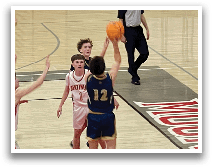 A group of young men playing basketball on a court. One player is attempting to block a shot. AI generated content