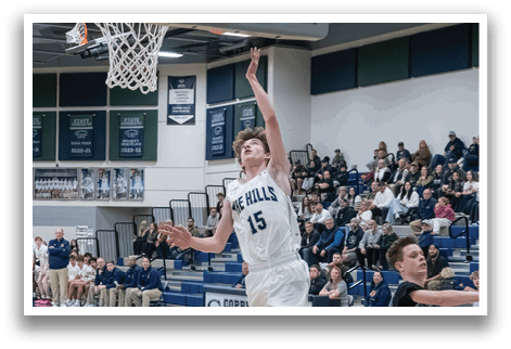 A basketball player leaps to catch a rebound in front of a crowd of spectators. AI generated content