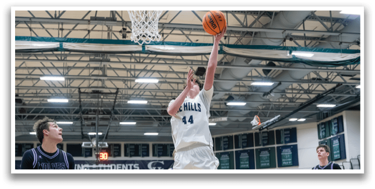 A basketball player leaps to block a shot, while two other players watch from the sidelines. AI generated content
