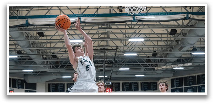 A basketball player leaps in the air to block a shot, while other players on the court watch the action. AI generated content