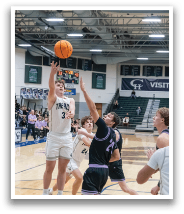 A group of men playing basketball in a gym. One player is jumping to block a shot. AI generated content