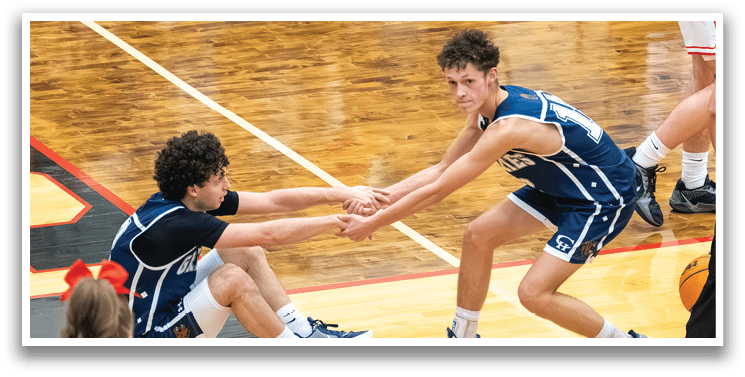 Two basketball players are seen hugging each other on the court. AI generated content
