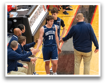 A basketball player is being congratulated by his coaches and teammates after a game. AI generated content