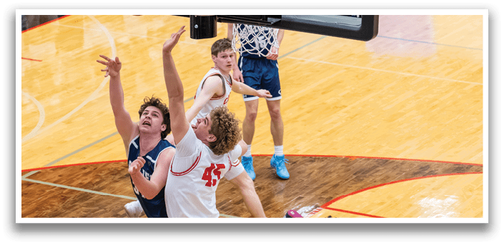 A group of men playing basketball, with one man attempting to block a shot. AI generated content