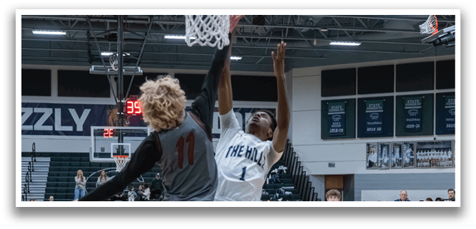 A basketball player leaps into the air to block a shot, while other players look on. AI generated content