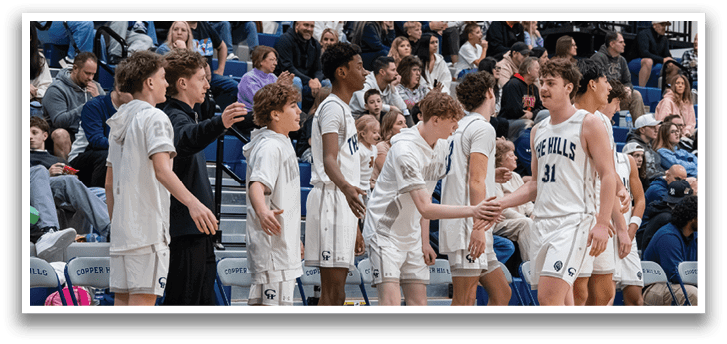 A group of young men are standing on a basketball court, wearing uniforms and holding hands. They are surrounded by a crowd of spectators. AI generated content