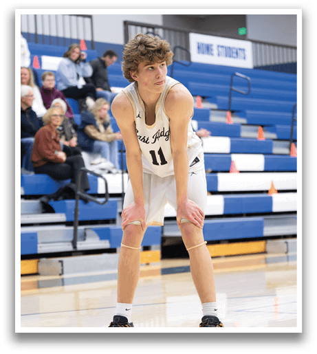 A basketball player in a white uniform is crouching on the court. AI generated content