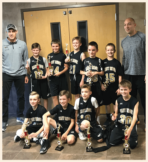 A group of young boys are holding trophies, posing for a photo. AI generated content
