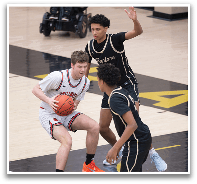Three basketball players on a court, one holding a basketball. AI generated content