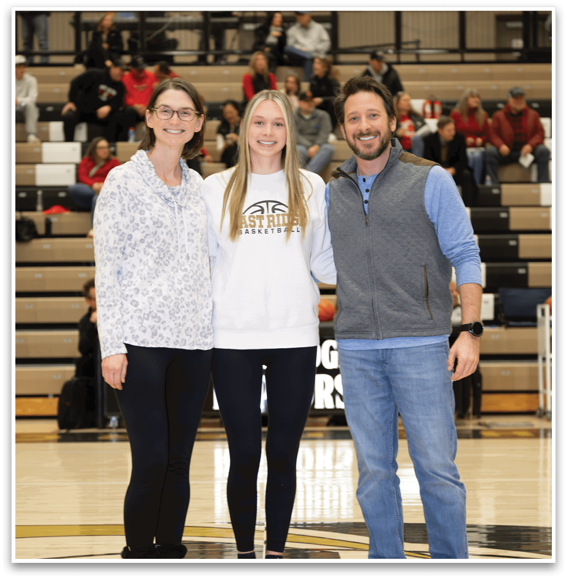 A man, woman, and girl pose for a photo on a basketball court. AI generated content