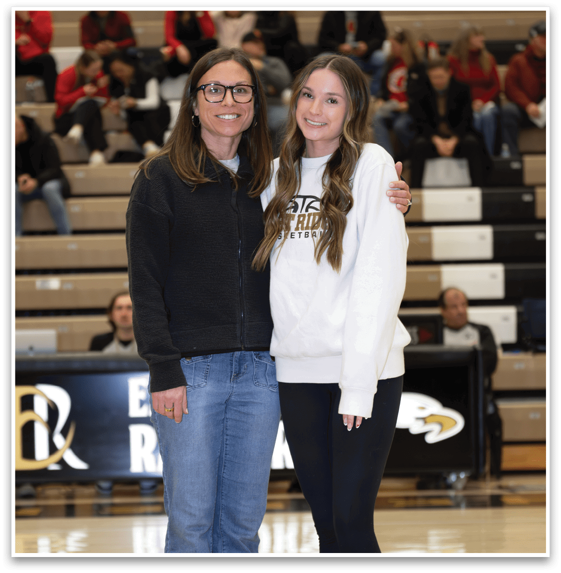 Two women standing on a basketball court, one wearing a white sweatshirt and the other wearing a black jacket. AI generated content