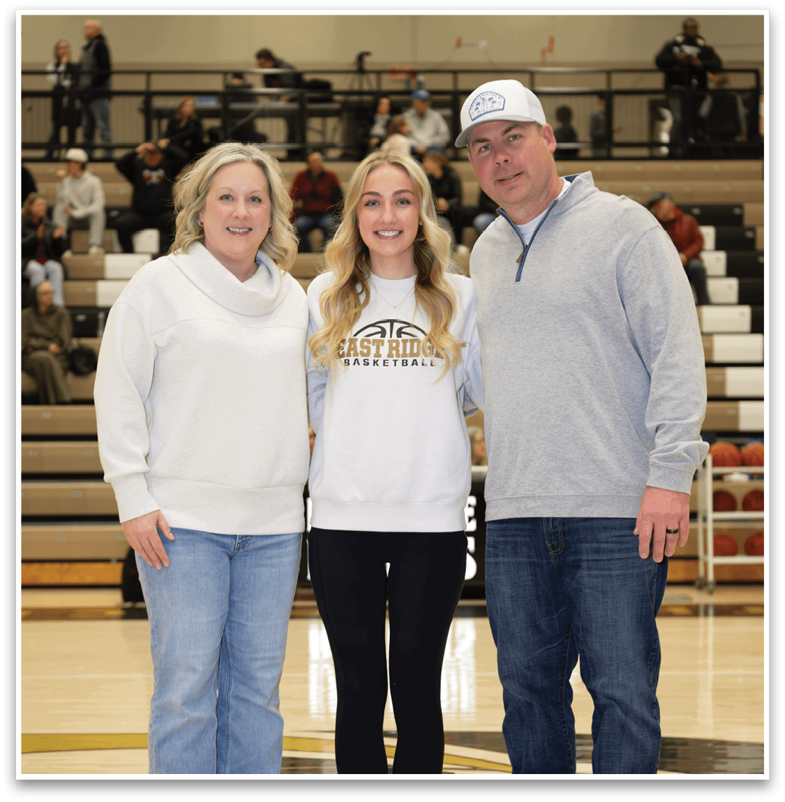 A man, woman, and girl pose for a photo on a basketball court. AI generated content