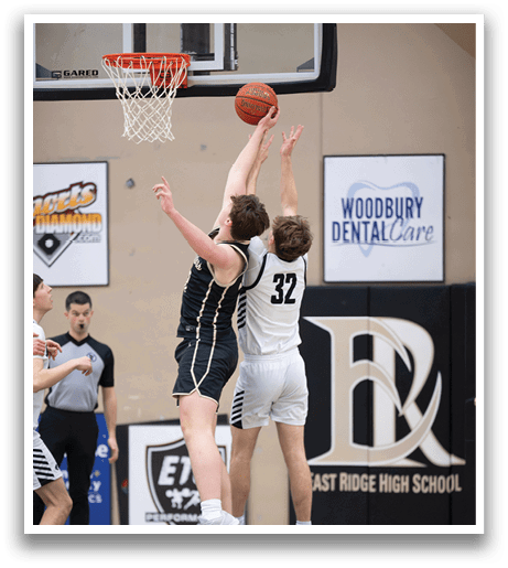 Two basketball players are jumping for the ball, one of them wearing a black and gold uniform. AI generated content