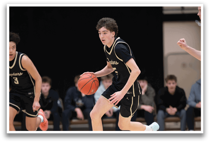 A basketball player in a black jersey is running with a basketball in his hand. AI generated content
