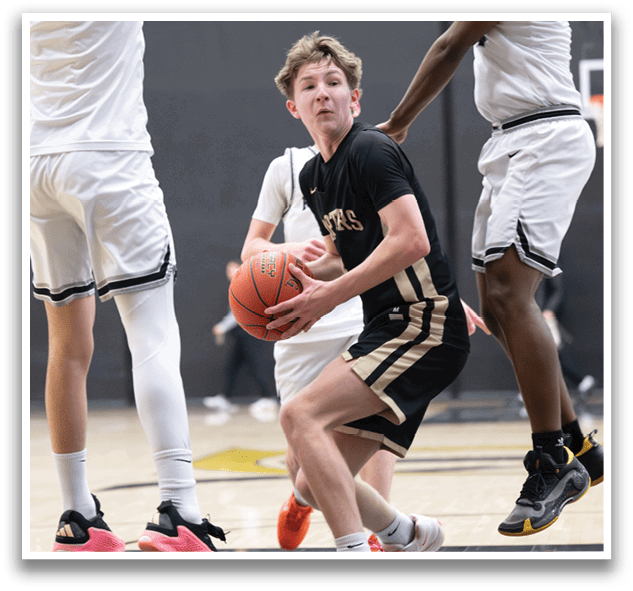 A basketball player in a black shirt and white shorts is holding a basketball while two other players jump in the air to try to block him. AI generated content