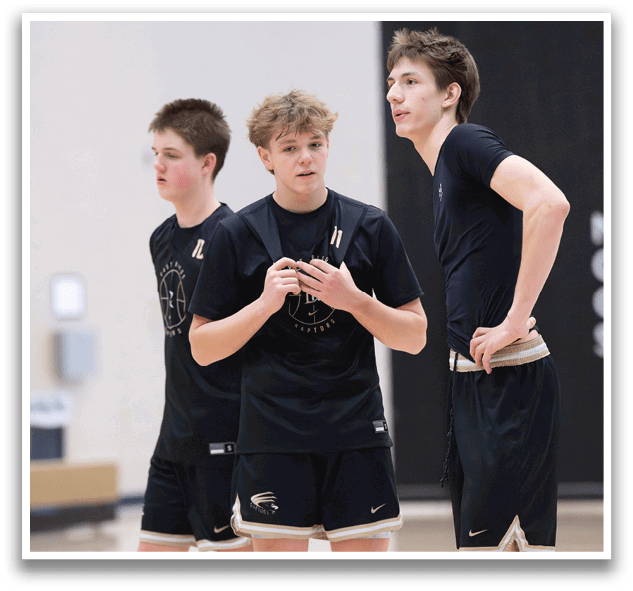 Three boys wearing black shorts and shirts are standing on a basketball court. AI generated content