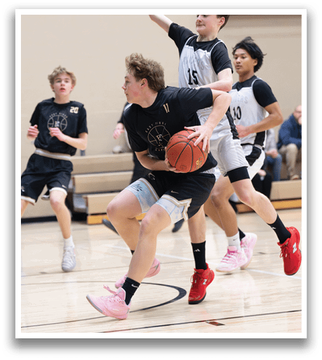 A group of young men playing basketball, with one player attempting to block another player from getting the ball. AI generated content