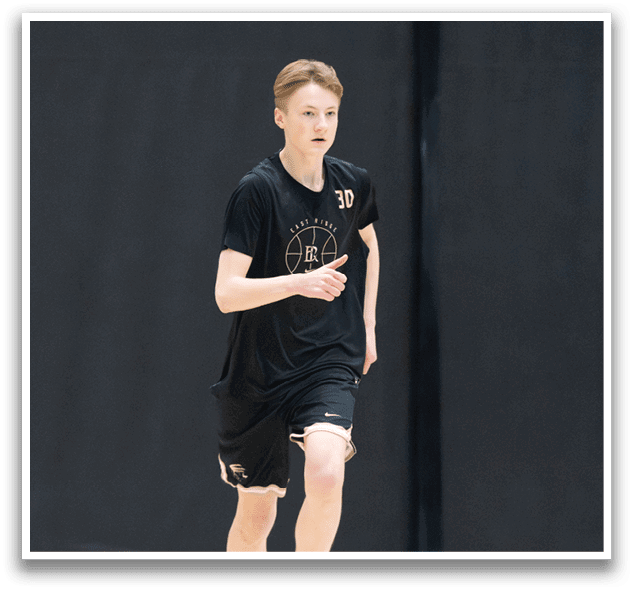 A young man wearing a black shirt and shorts is running on a basketball court. AI generated content