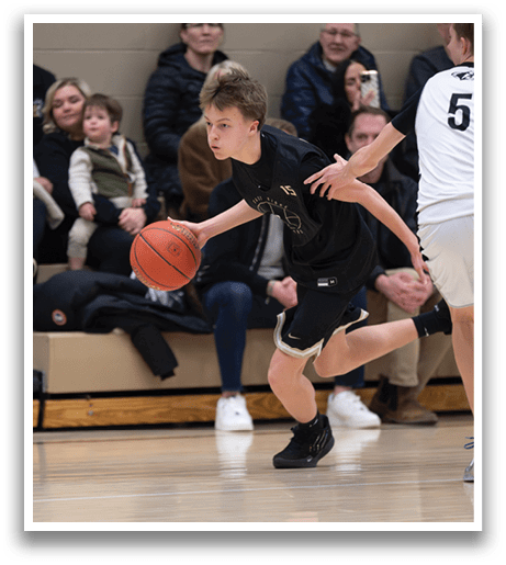 A young boy is playing basketball, holding a basketball in his hands. AI generated content