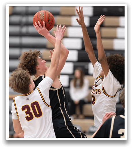 A group of basketball players are playing a game, with one player jumping up to block a shot. AI generated content