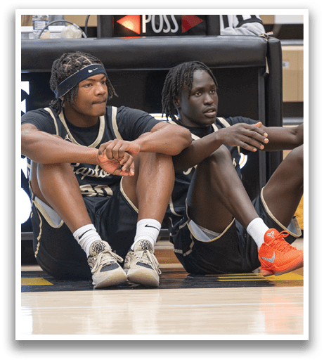 Two men wearing basketball uniforms are sitting on the floor. AI generated content
