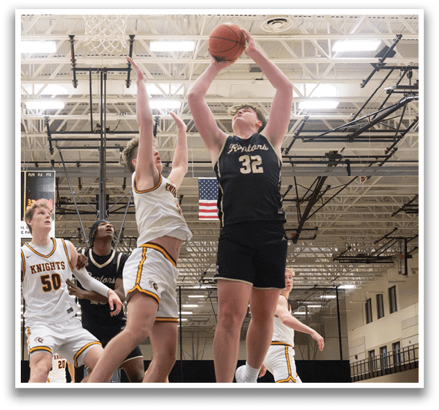 A basketball game is in progress with players on the court. One player is jumping to block a shot, while another player is attempting to shoot the ball. The scene is set in a gymnasium with a hoop and a net. AI generated content