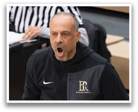 A man wearing a black hoodie and black pants is standing on a basketball court. AI generated content