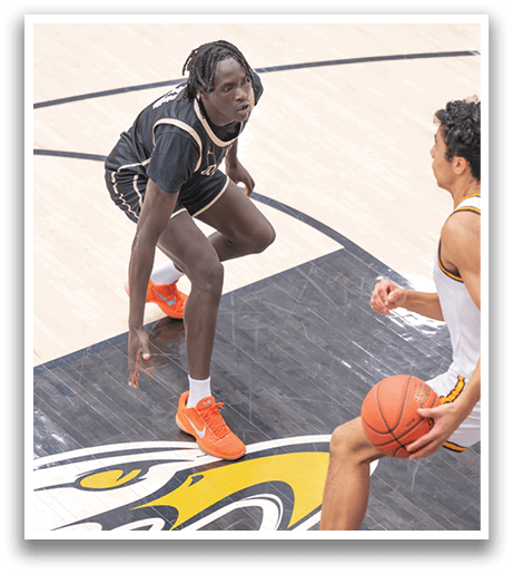 Two basketball players on the court, one with a ball and the other with a hand on the ground. AI generated content