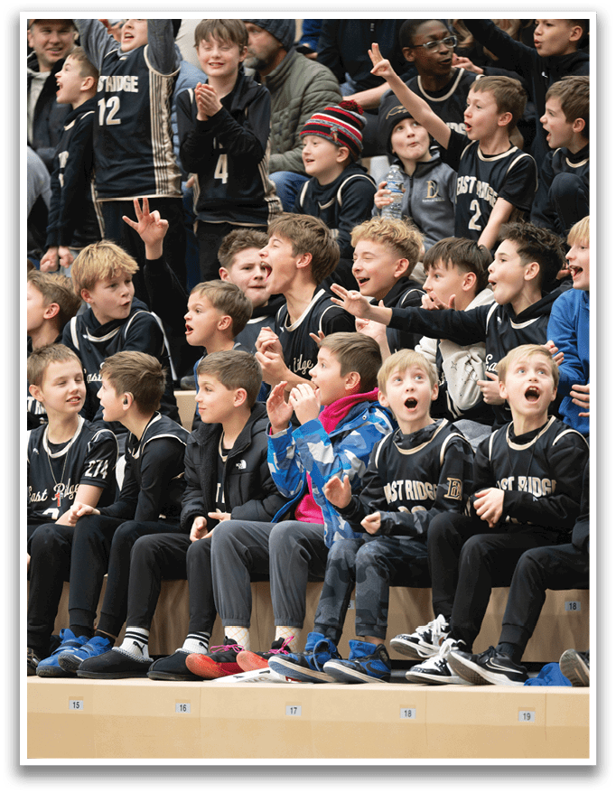 A group of young boys wearing basketball jerseys are sitting on a bench, watching a game. AI generated content