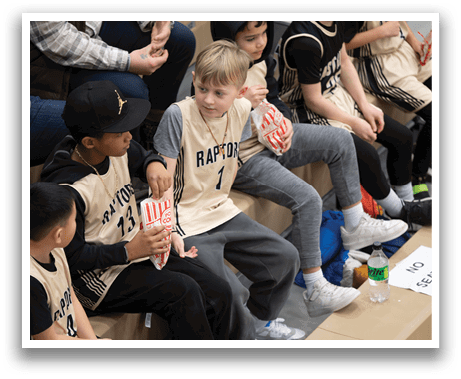 A group of young boys are sitting on a bench, eating popcorn. AI generated content