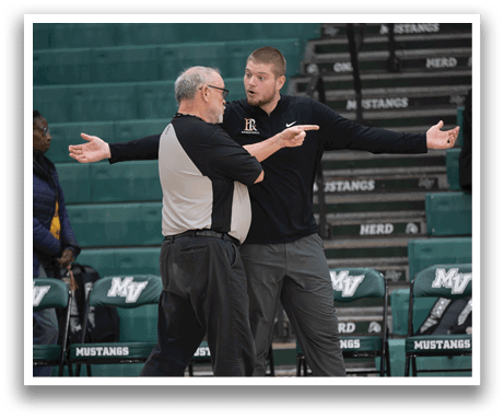 Two men are standing on a basketball court, engaged in a conversation. One man is wearing a referee's shirt, while the other is wearing a black shirt. They are both facing each other, with their arms outstretched. AI generated content