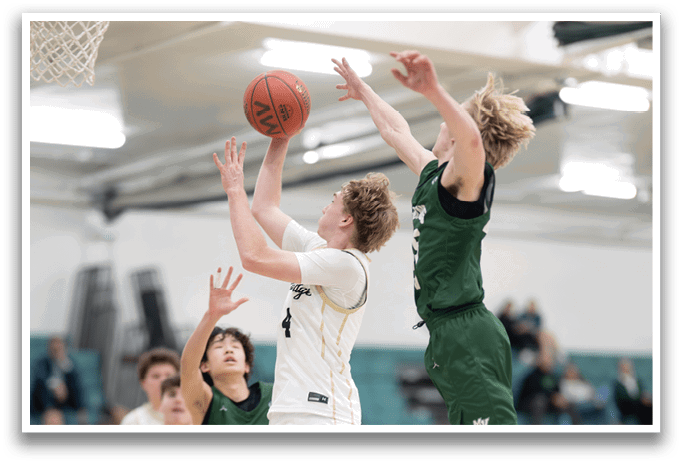 A basketball game is in progress with players on the court. One player is jumping up to grab the basketball while another player tries to block him. The players are wearing uniforms and are actively engaged in the game. AI generated content