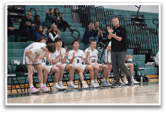 A group of young men are sitting on chairs in a gym, with one man standing and clapping. AI generated content