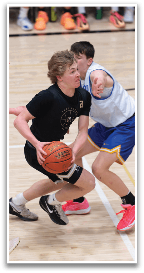Two men are playing basketball, one holding a ball and the other trying to block him. AI generated content