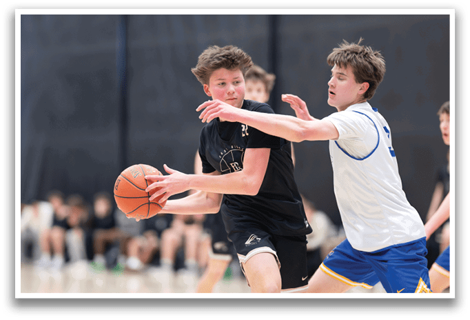 Two young men are playing basketball, one holding a basketball and the other trying to block him. AI generated content