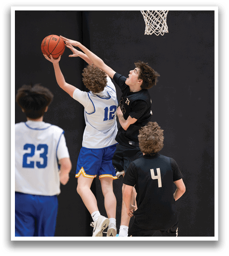 A group of young men playing basketball, with one man jumping to block a shot. AI generated content