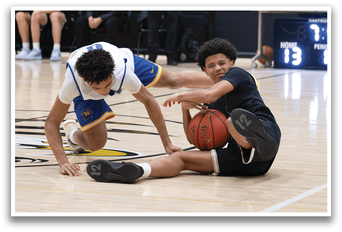 Two men are playing basketball, one is on the floor holding a basketball while the other is trying to take it from him. AI generated content
