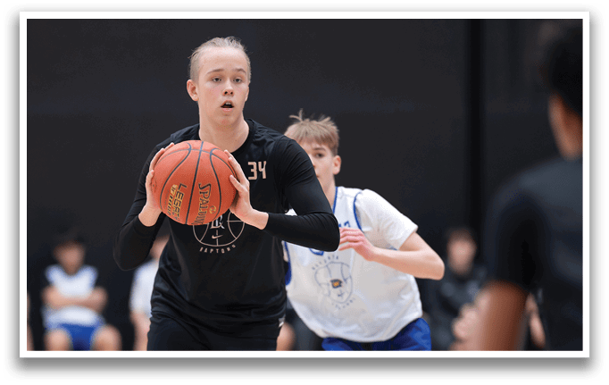 A woman in a black shirt and shorts holds a basketball in front of her face. A boy in a white shirt and blue shorts is running towards her. AI generated content