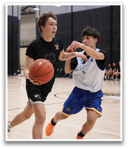 Two young men are playing basketball on a court. One of them is holding a basketball while the other is trying to block him. AI generated content