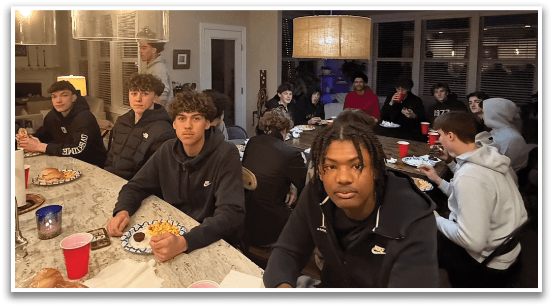 A group of people are sitting around a dining table, enjoying a meal together. AI generated content