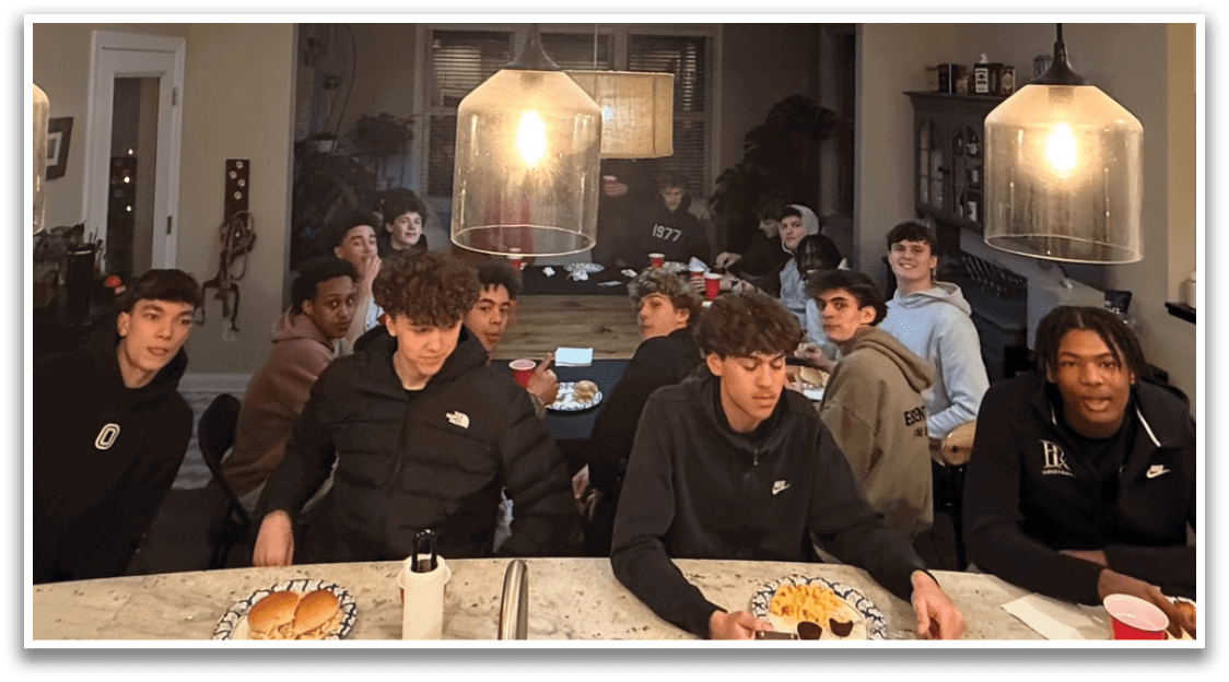 A group of people are sitting around a dining table, enjoying a meal together. AI generated content