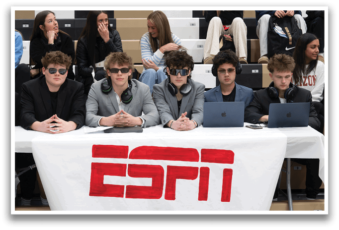 A group of young men are sitting at a table with laptops, headphones, and sunglasses. They are wearing suits and appear to be working or studying. AI generated content