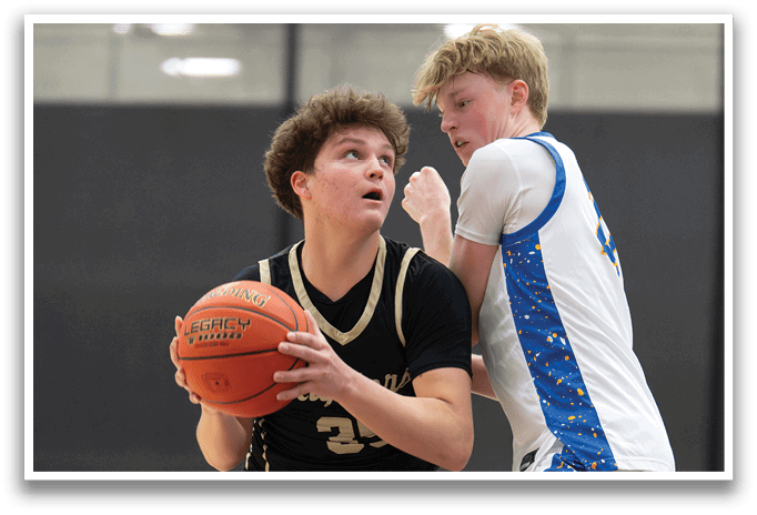 Two basketball players are on the court, one holding a basketball and the other trying to block him. AI generated content
