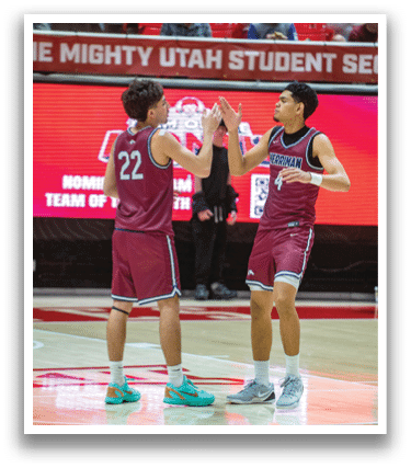 Two men wearing red uniforms are high-fiving each other on a basketball court. AI generated content