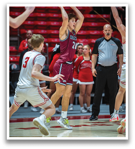 A basketball player in a red jersey shoots the ball while a referee and other players watch. AI generated content