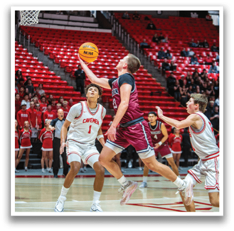 A basketball player leaps to block a shot, while another player tries to get past him. AI generated content