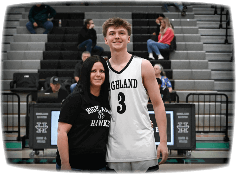 A man and woman are standing on a basketball court, posing for a picture. The man is wearing a basketball uniform and holding the woman in front of him. AI generated content