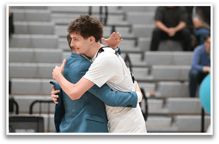 Two men embrace each other on a basketball court. AI generated content